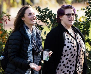 Two female students walk through campus.