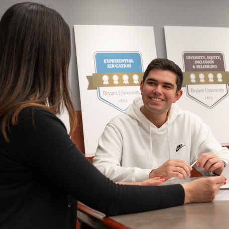 Jason Ferrero sits with a career advisor in Bryant's Amica Center for Career Education.