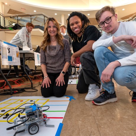 Bryant students pose with a robotics project.