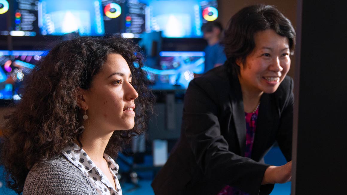 Bryant Professor Suhong Li works with a student in the Data Visualization Lab.