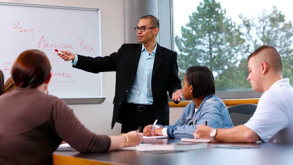 Bryant Professor Jeffrey Cabusao with students in the classroom